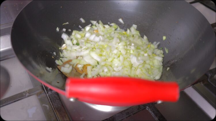 making Coriander rice in a wok with sauteeing onions