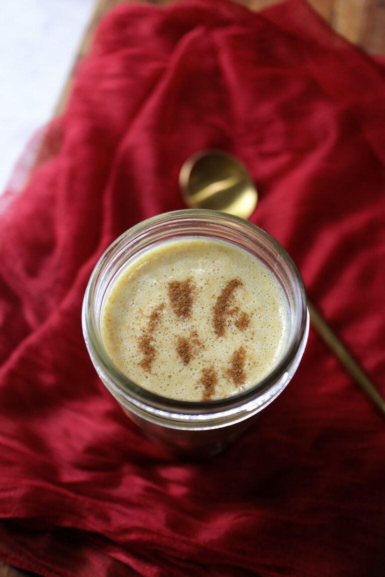 A glass jar with a spoon and cinnamon, ready to spice up your post-run nut butter smoothie.