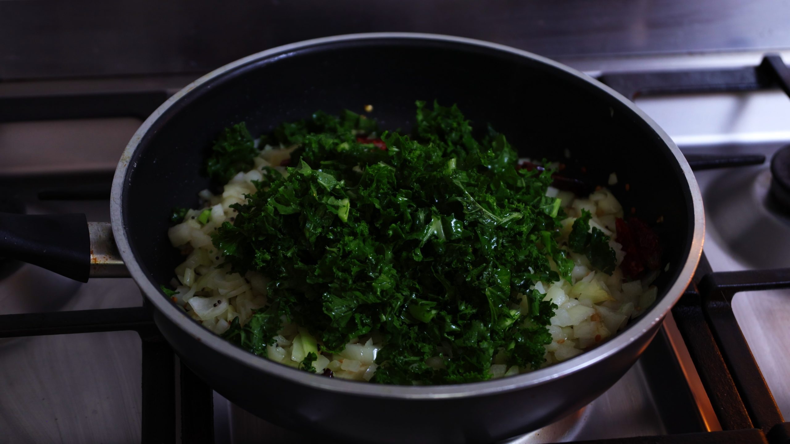 kale stir fry in a pan on a stove