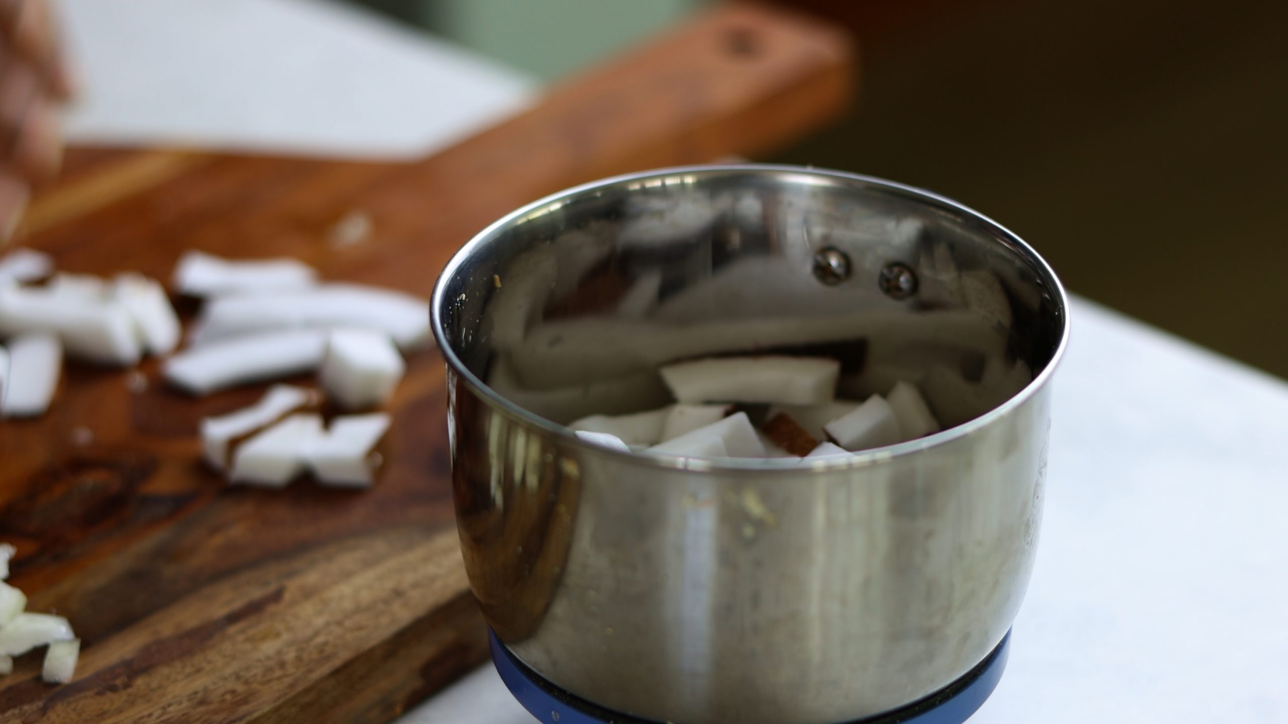 chunks of coconut in a mixer grinder for making kale stir fry