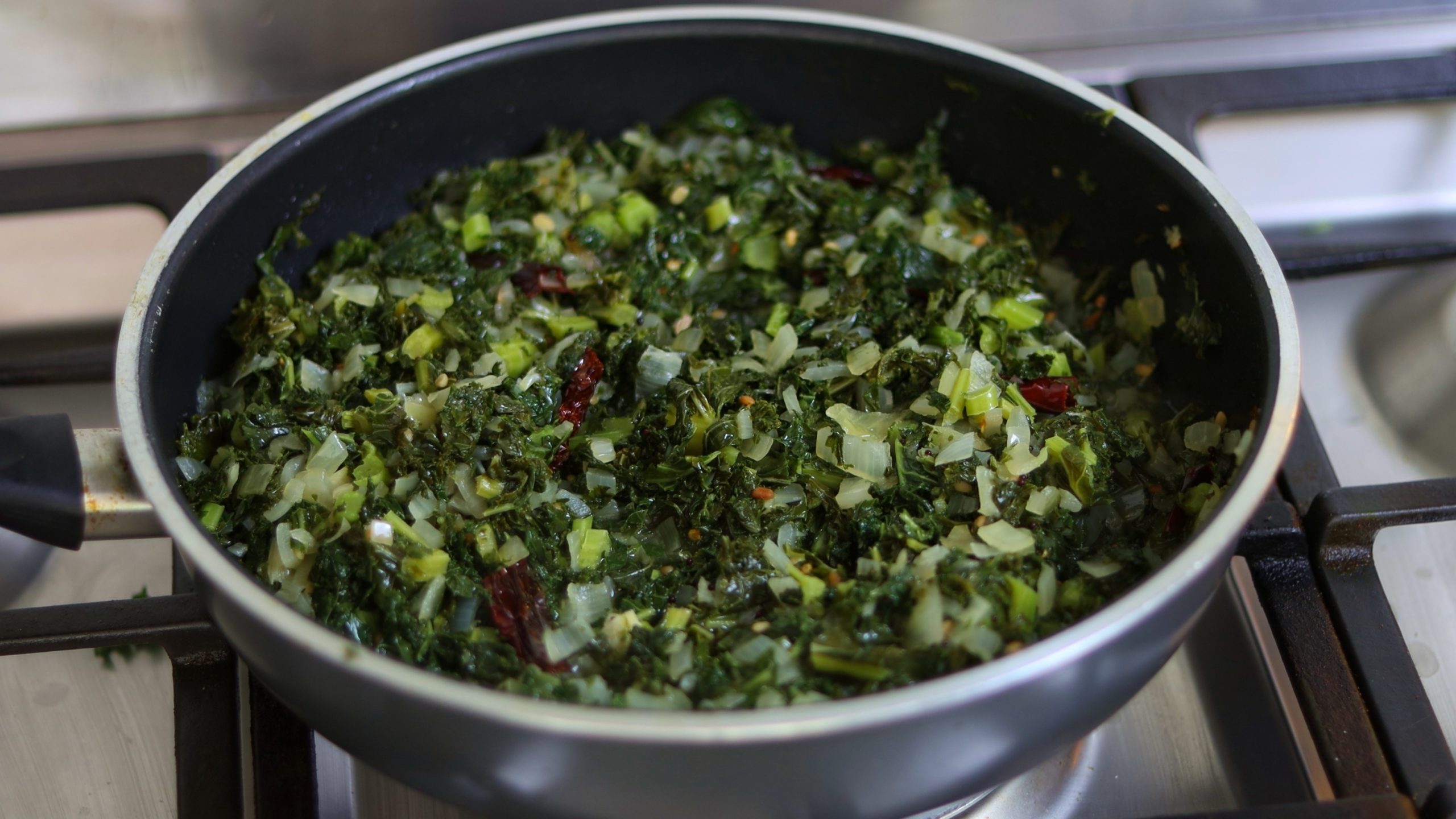 kale stir fry in a pan on a stove