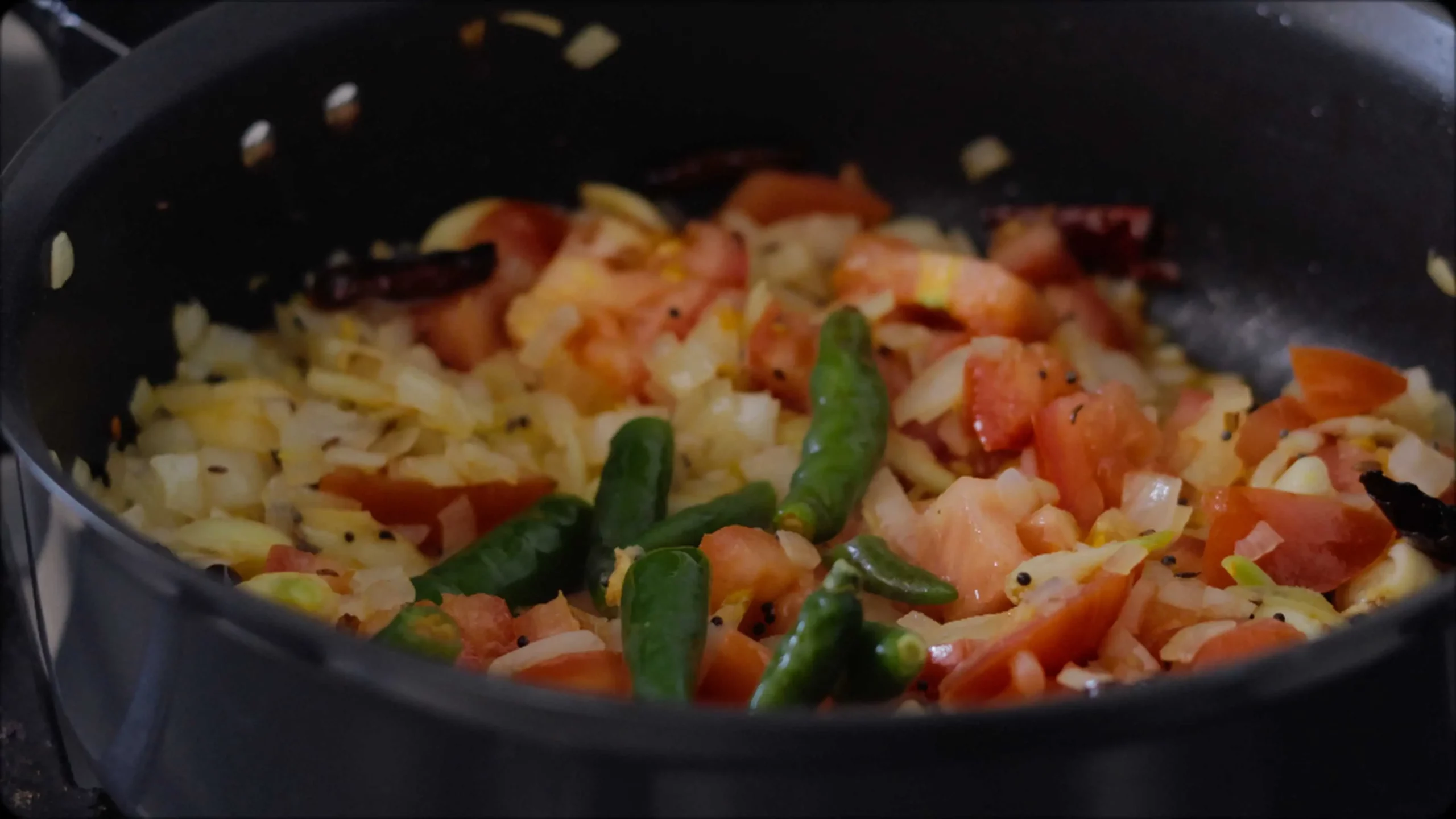 sauteeing with mustard, cumin seeds and red chillies, diced tomatoes for making methi dal