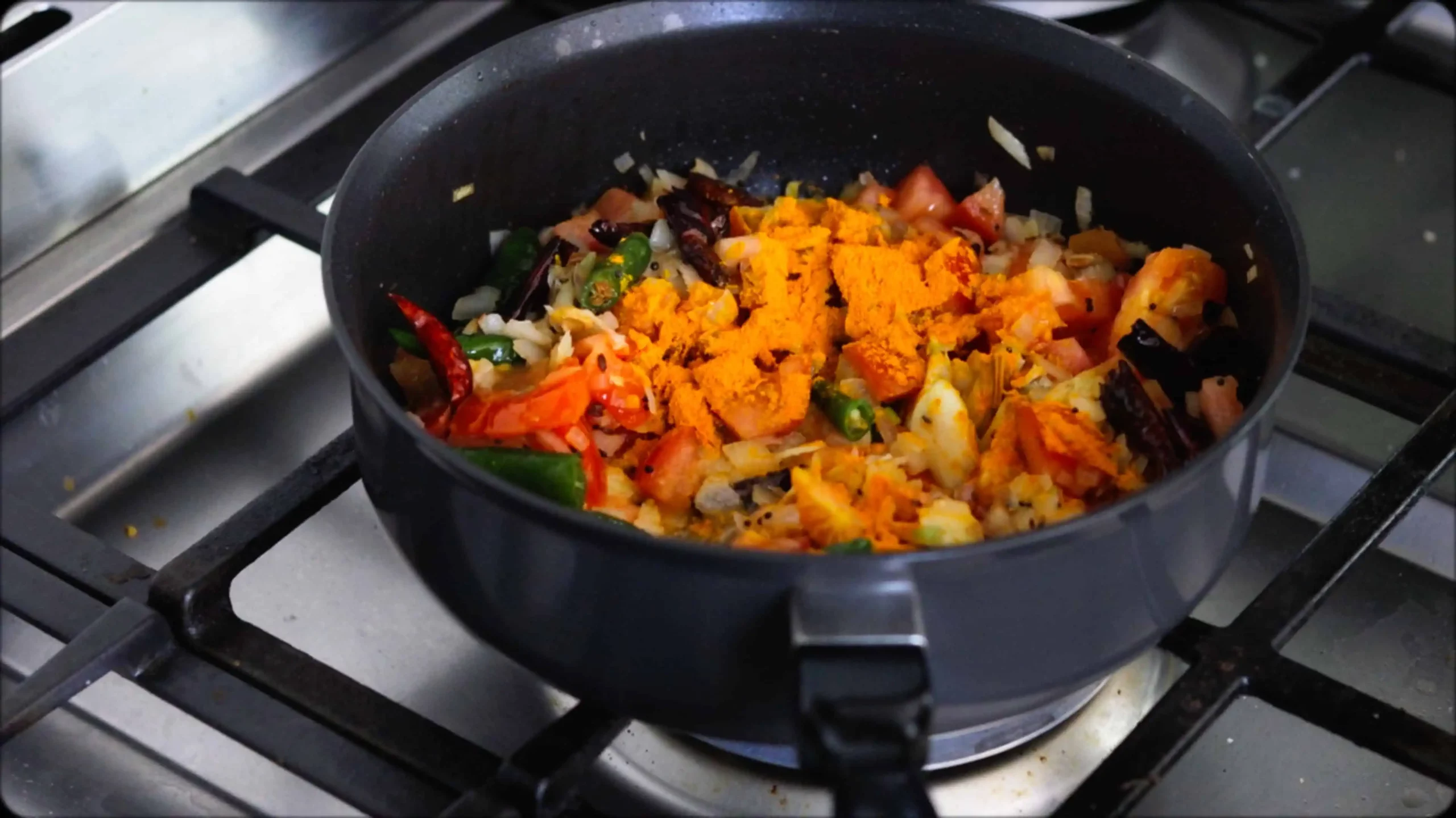 sauteeing with mustard, cumin seeds and red chillies, diced tomatoes for making methi dal