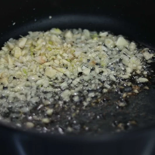 sauteeing garlic for making tin tomato pachadi