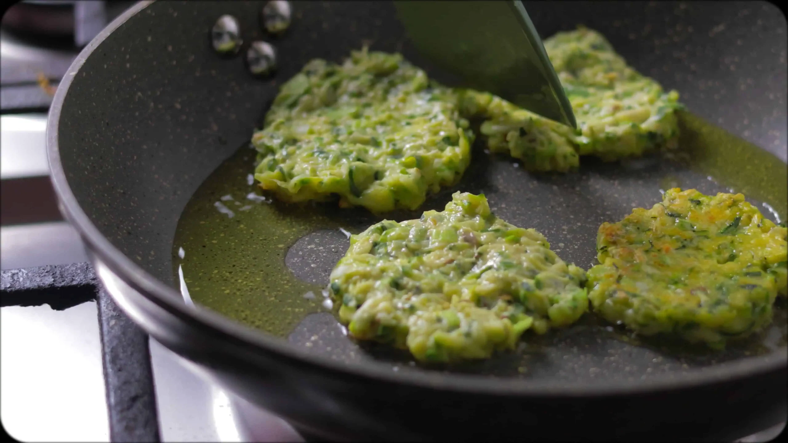 Bowl of zucchini fritter batter showing combined ingredients with visible herbs and spices