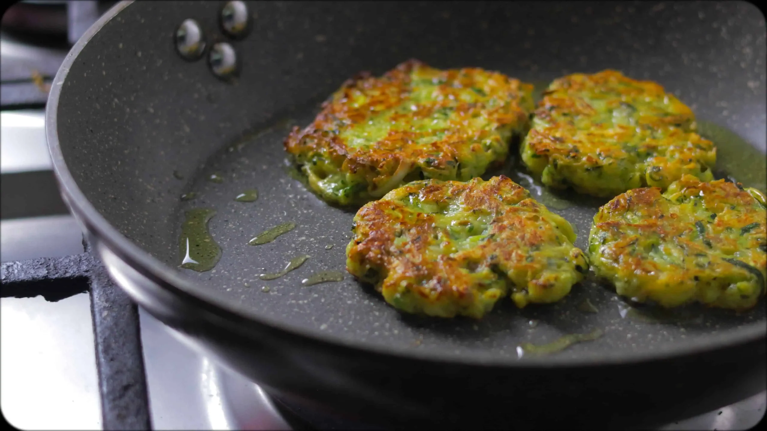 Bowl of zucchini fritter batter showing combined ingredients with visible herbs and spices