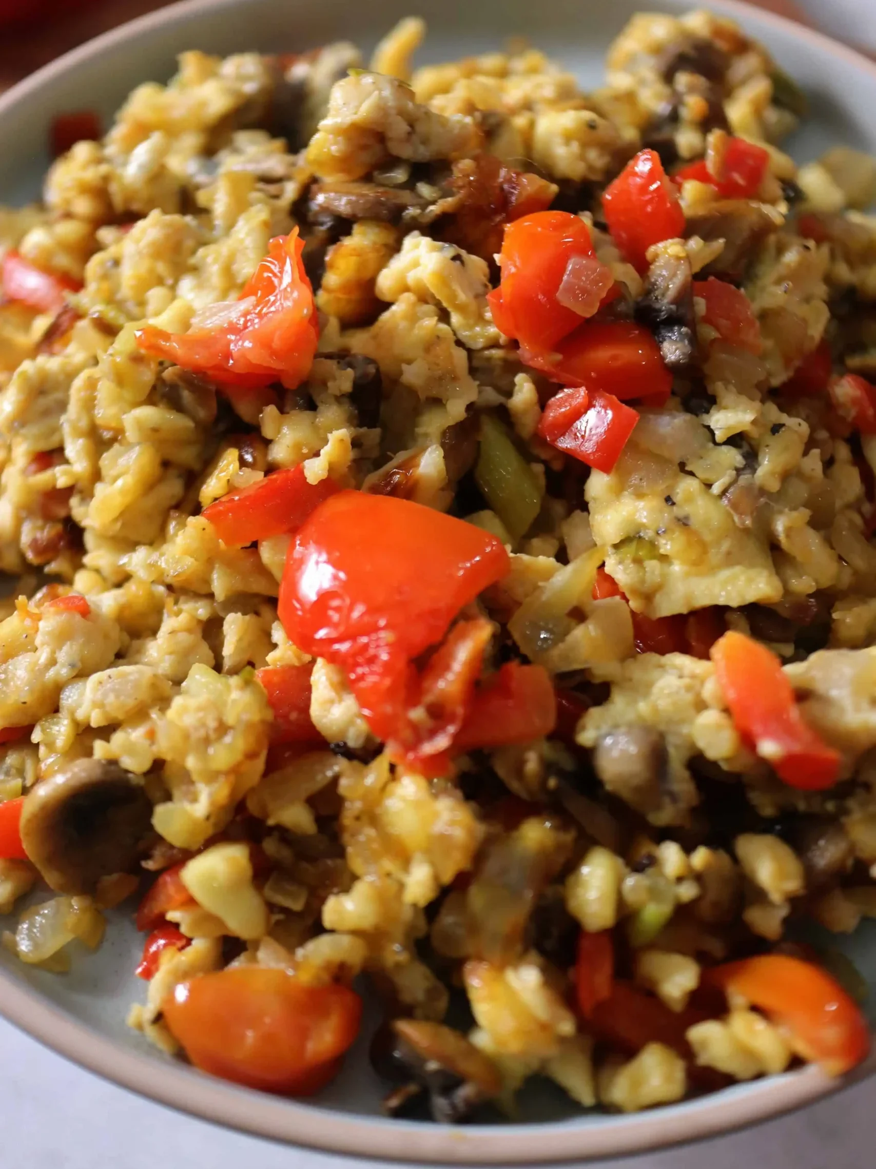 Steaming hot Paneer Bhurji being stirred in the pan, showing its perfect moisture level and vibrant orange-yellow color with specks of green herbs